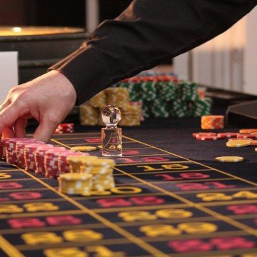A person placing game chips on a Roulette table