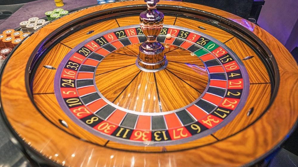 A Roulette wheel with game chips in the background
