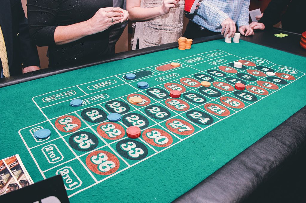  People placing bets at a roulette table
