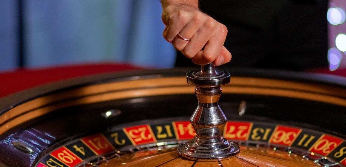 Roulette players around a wheel.